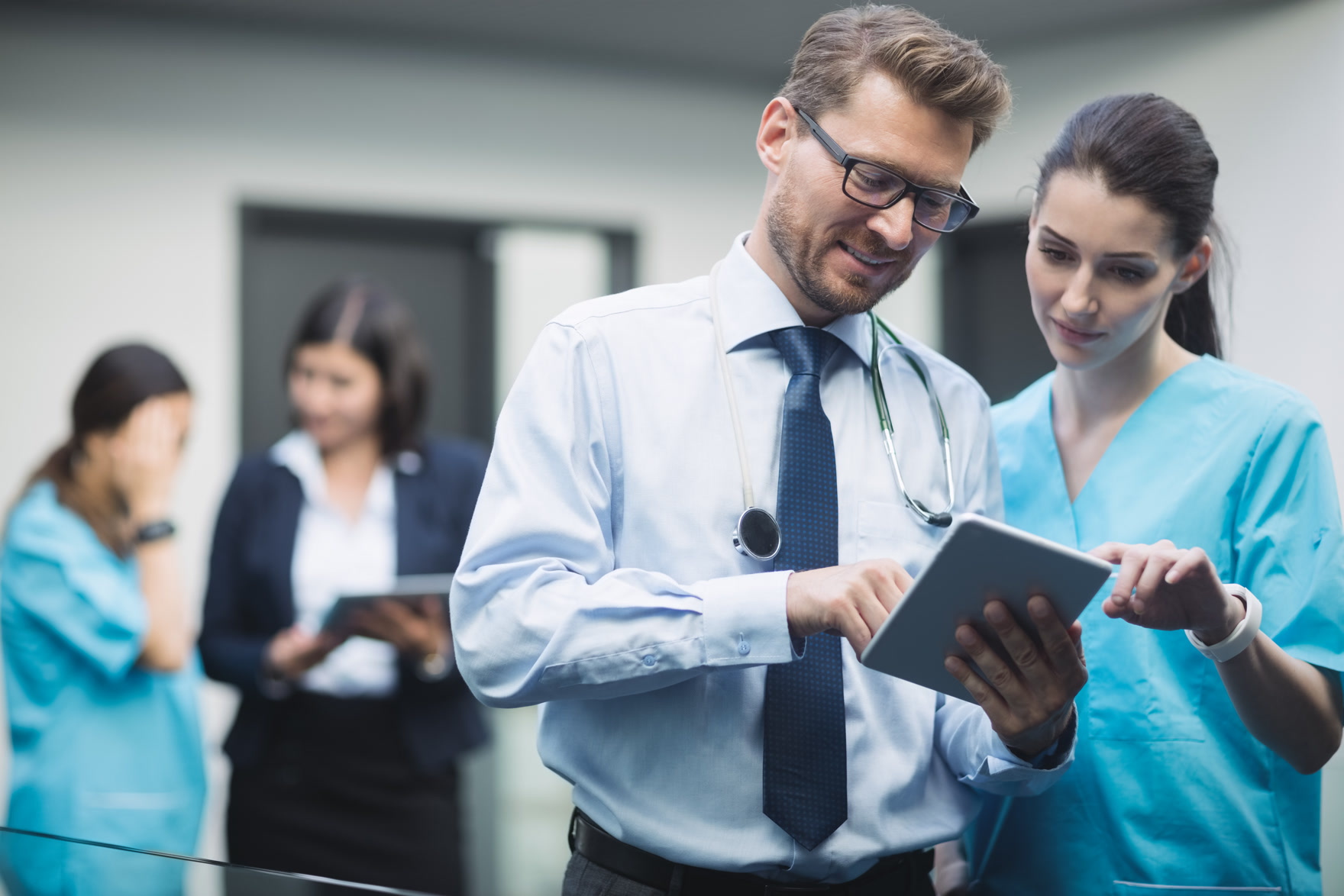 Healthcare professionals reviewing information on a tablet