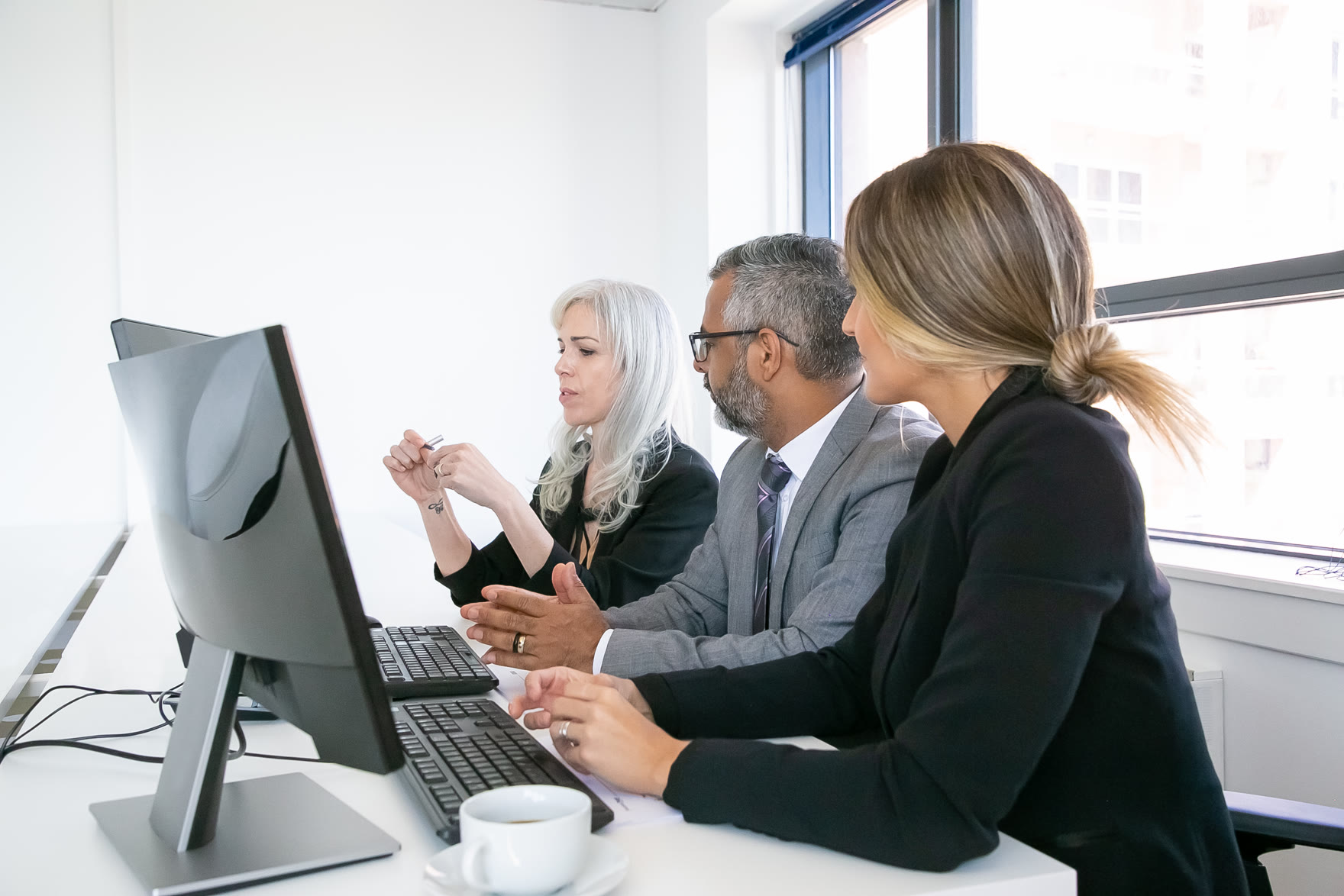 Technology team discussing a project in front of monitors